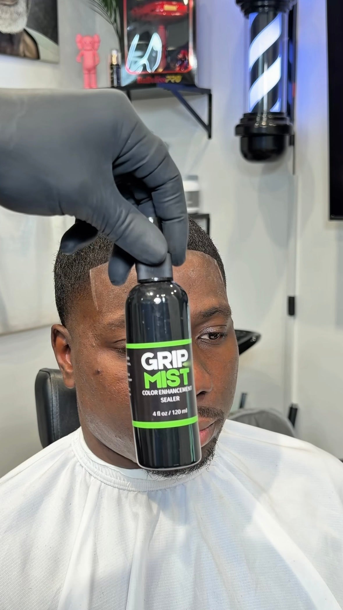 @marithabarber marithabarber holding a bottle of Grip Mist in a barbershop setting